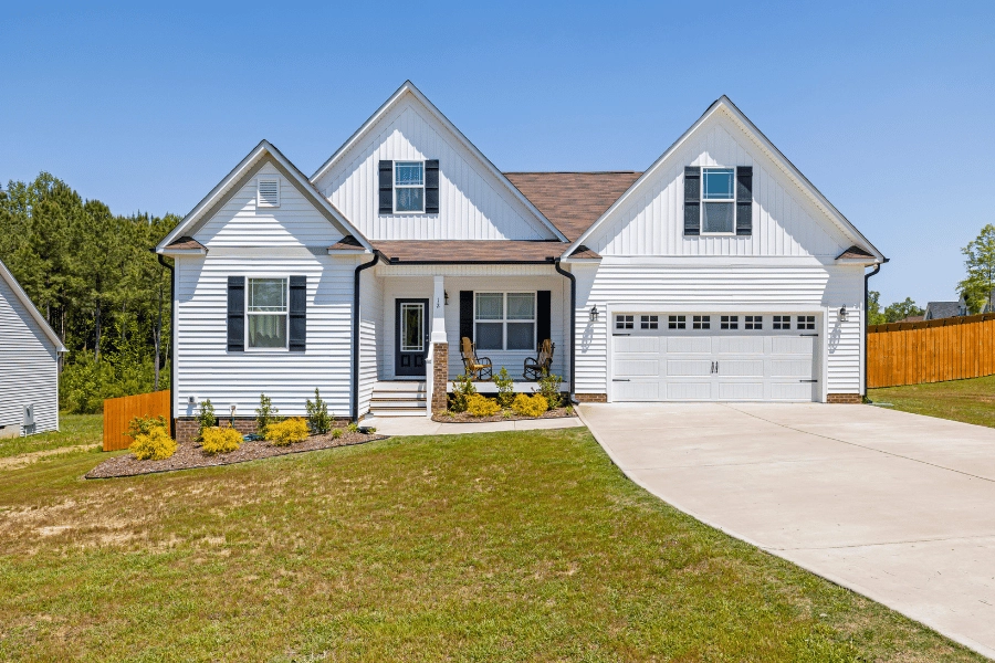 white home with black shutters and a front porch in a neighborhood